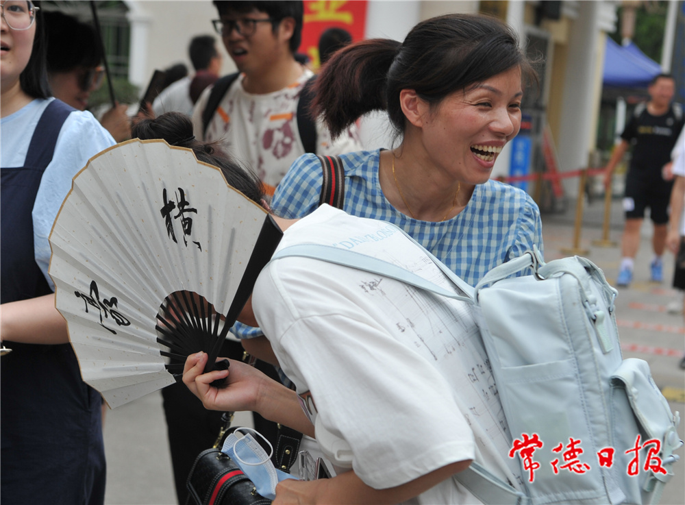 6月9日，在常德市一中考點，中午下考后，一名考生拿著一把寫著“豪橫”兩字的折扇，信心滿滿地走出考場，被前來迎考的媽媽一把抱住，激動之情溢于言表。本報記者 陳歡 攝.jpg