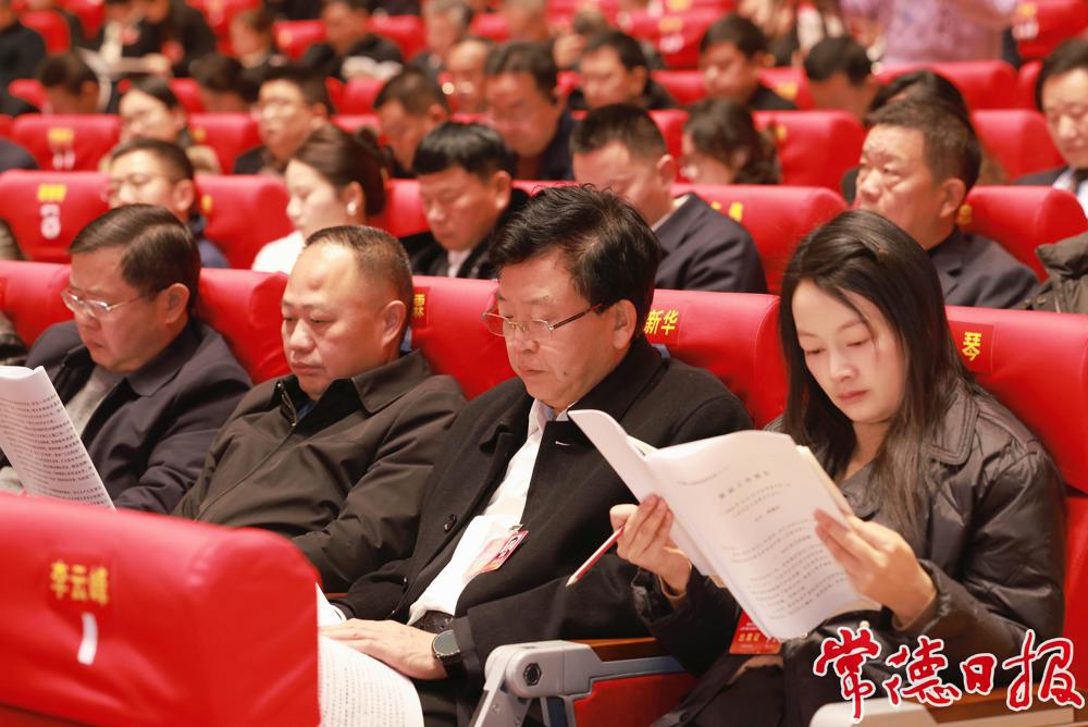 與會代表認真閱讀政府工作報告